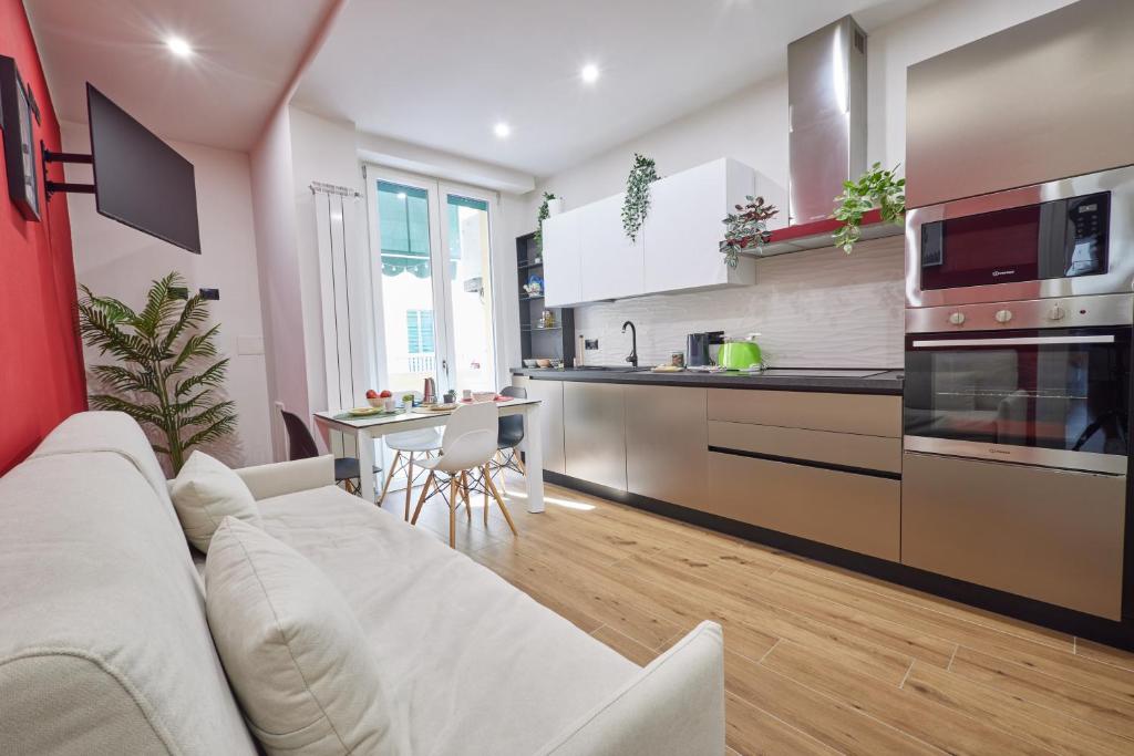 a living room with a white couch and a kitchen at [San Donato] Jewel Apartment in Florence