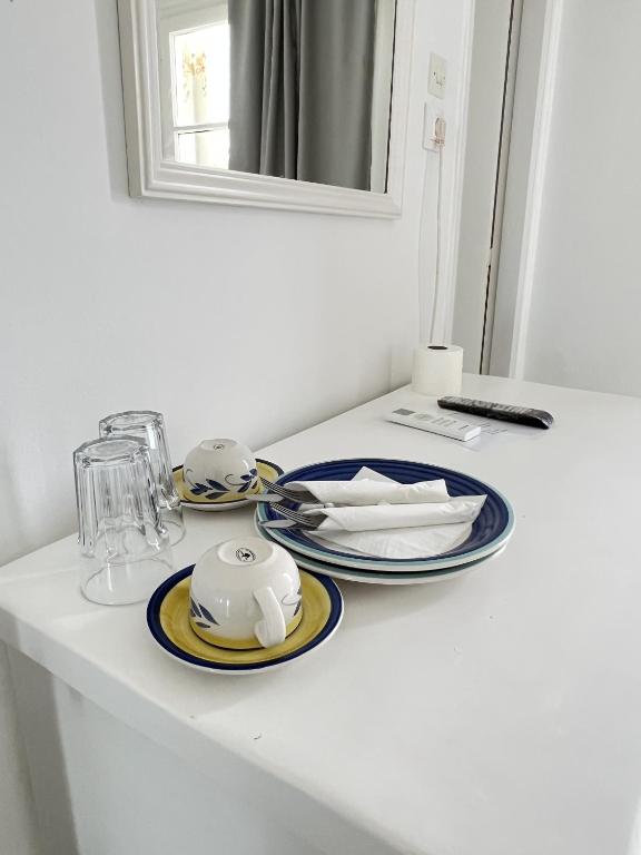 a white table with plates and dishes on it at Hotel Anezina in Drios