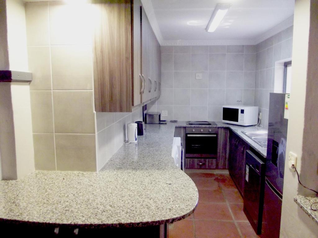 a kitchen with a counter top and a microwave at Caribbean Estates Montego Bay 05 in Port Edward