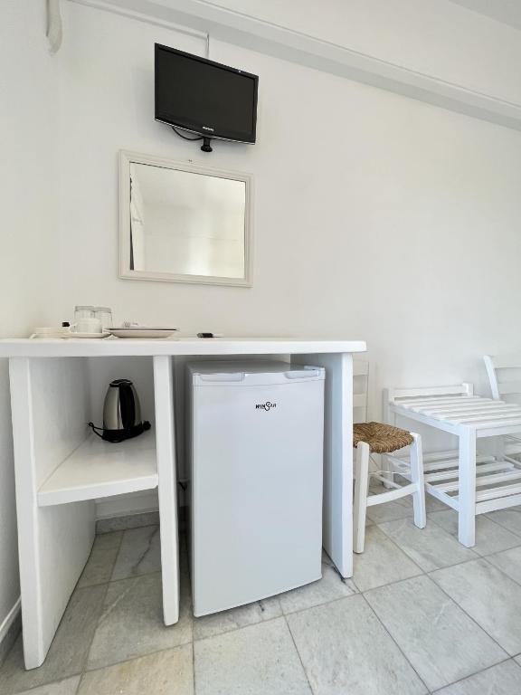 a white desk with a tv on top of it at Hotel Anezina in Drios