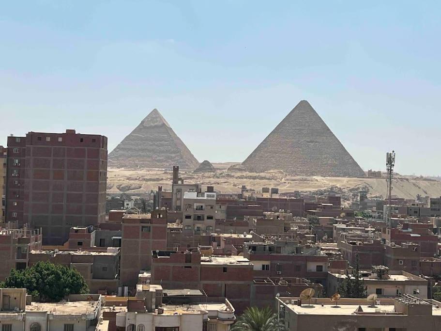 een stad met de piramides op de achtergrond bij Pyramids view apartment 3BR in Caïro