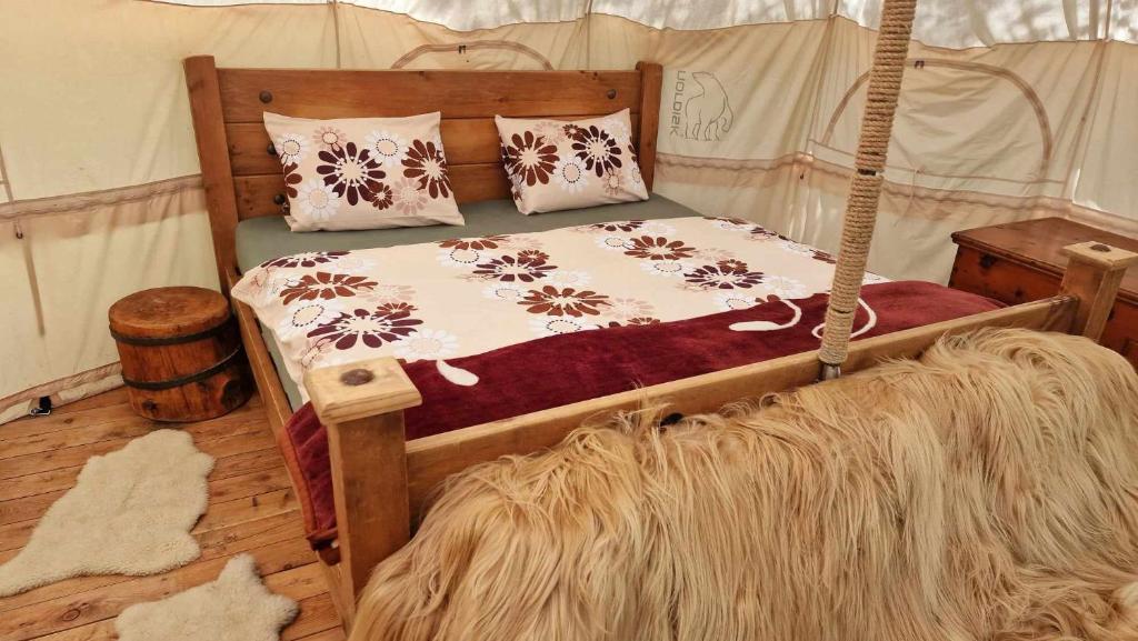 a bedroom with a bed in a tent at Glamping Stola- Šepot kvetov in Štôla