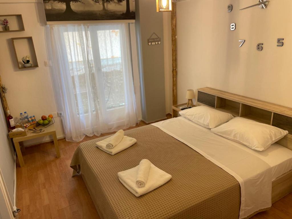 ein Schlafzimmer mit einem großen Bett mit zwei Handtüchern darauf in der Unterkunft MY HOME PERISTERI in Athen