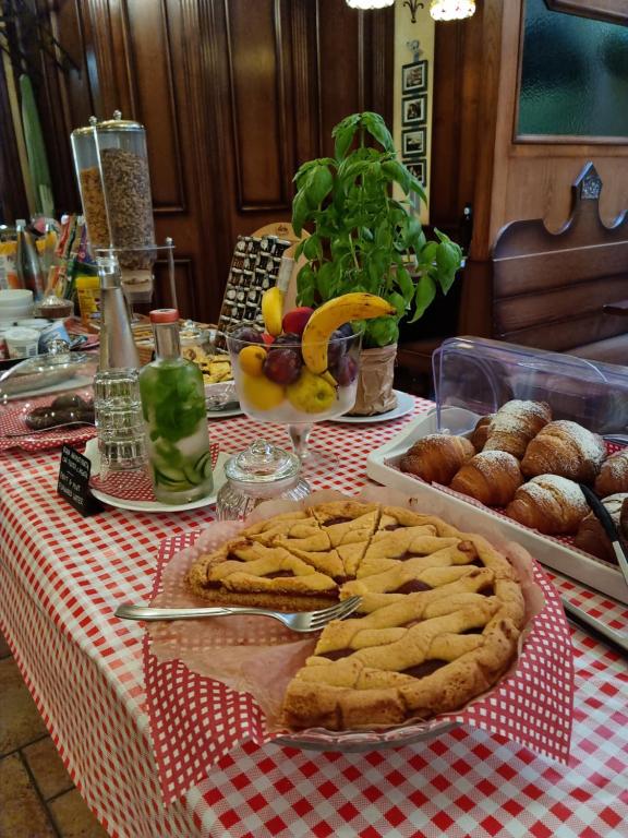 a table with cookies and other pastries on a red and white table cloth at Hotel Vittoria in Riva del Garda