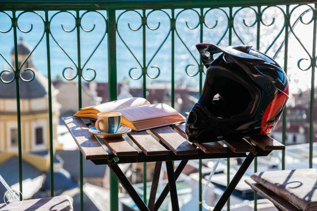 a table with a backpack and a book and a cup of coffee at Casa Vacanze Casa Barbara in Finale Ligure