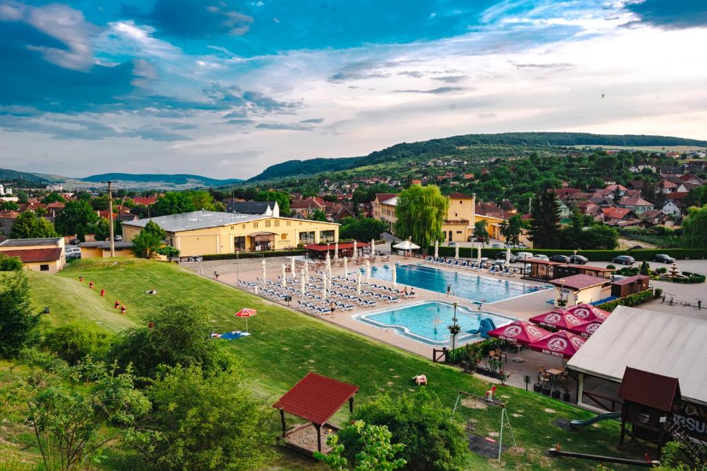 un complexe doté d'une piscine avec des chaises longues et des parasols dans l'établissement Septimia Hotels & Spa Resort, à Odorheiu Secuiesc