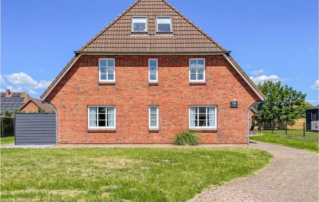 a large red brick house with a gambrel roof at Beautiful Apartment In Dagebll With Kitchen in Dagebüll