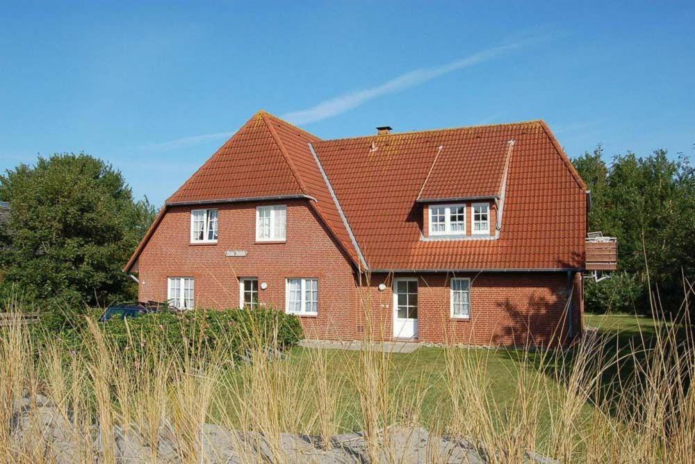 a red brick house with a red roof at Meene Menten Ferienwohnung Nr 04 in Süderhöft