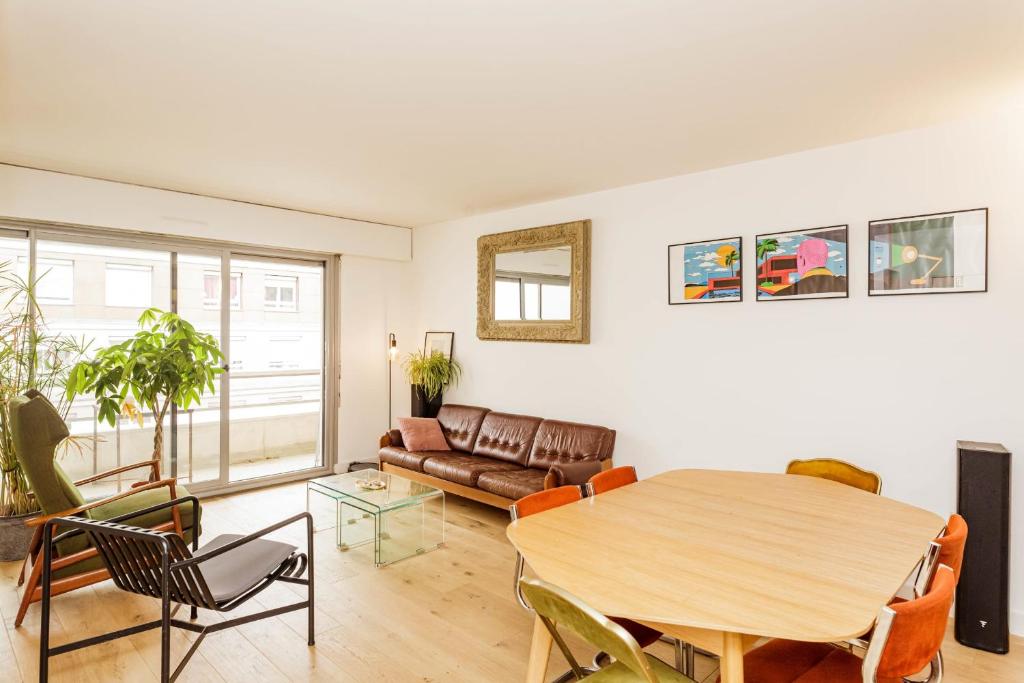 uma sala de estar com uma mesa e um sofá em Bright apartment with double terrace em Paris