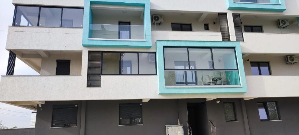 a building with blue windows on the side of it at Mara Apartment in Năvodari