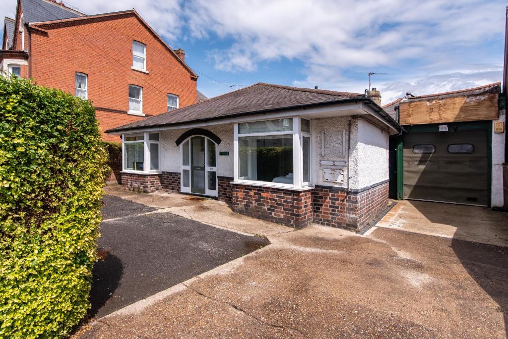 Casa blanca con ventana y entrada en Gertrude House - Spacious 3BR Bungalow in Nottingham, en Nottingham