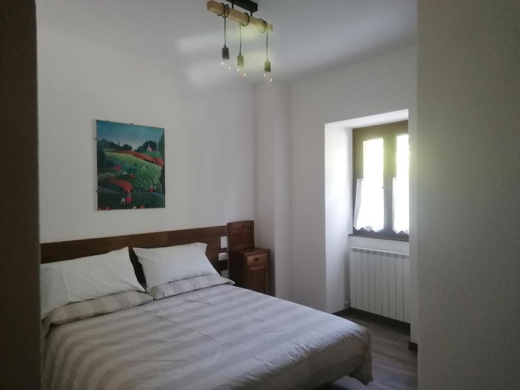 a bedroom with a bed and a window at Sweet Home Casa Vacanze il b&b in Songavazzo