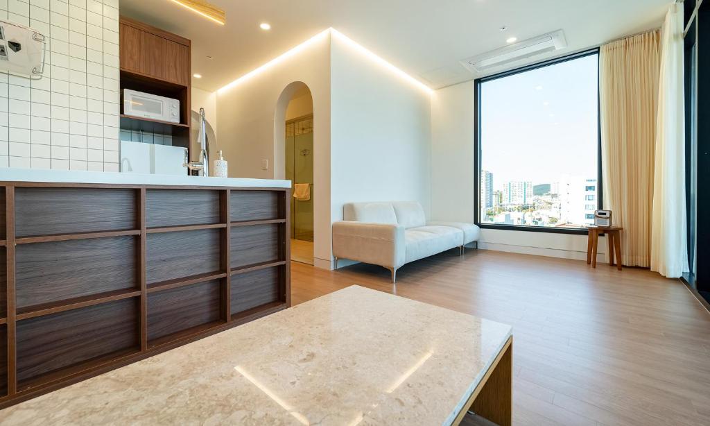 cocina y sala de estar con ventana grande en Paul Mare Pool Villa en Busan