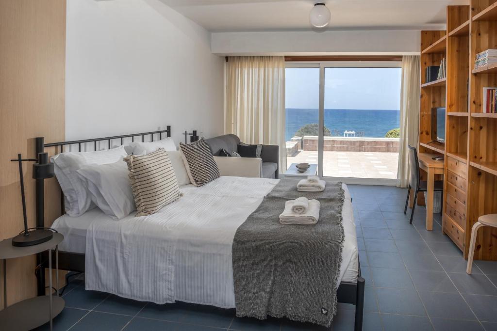 a bedroom with a bed with a view of the ocean at Ascuri Studio by Estia in Sissi