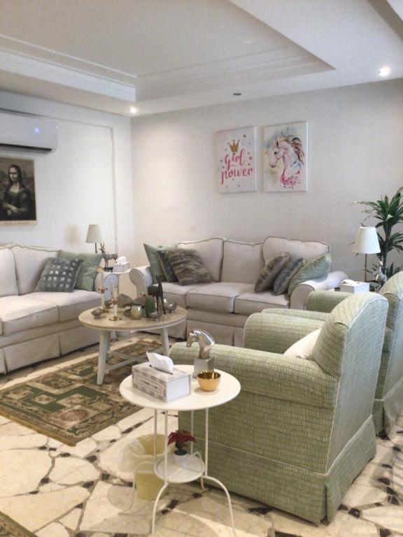 ein Wohnzimmer mit 2 Sofas und 2 Tischen in der Unterkunft سمو 4 in Riad