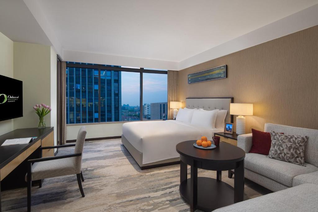 a hotel room with a bed and a living room at Oakwood Residence Hangzhou - Close to Westlake and Yellow Dragon Stadium in Hangzhou