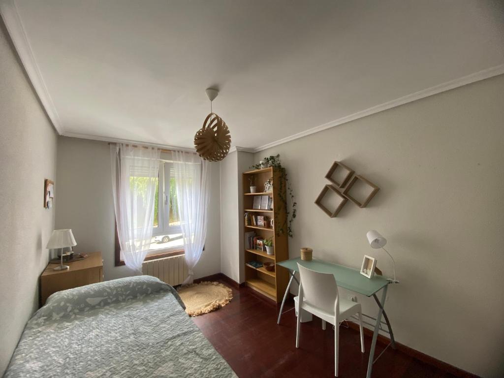 een slaapkamer met een bed, een tafel en een raam bij Habitación privada para 2 personas a 10 min de la playa in Santander