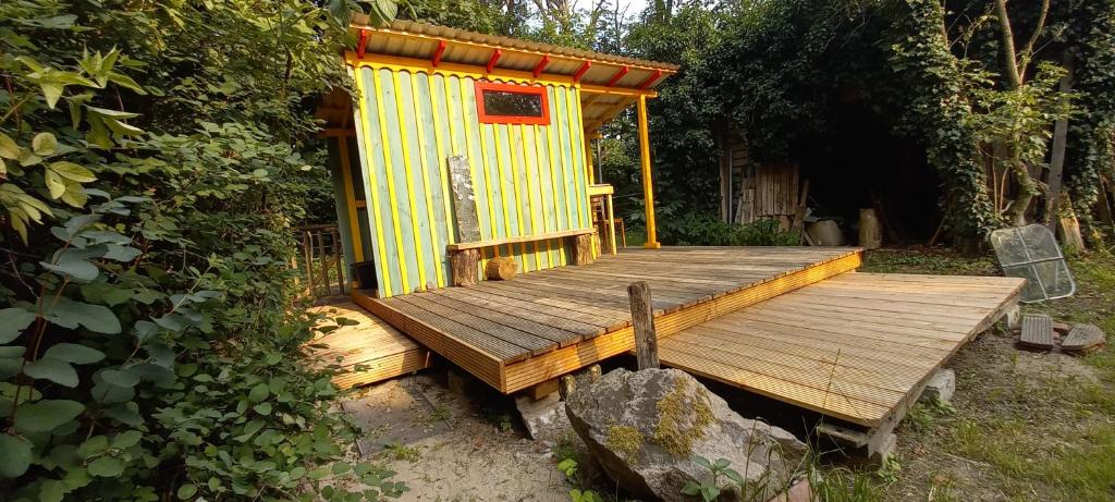 een geel huis met een houten terras bij Einfachlosmachen-Zeltpunkt 