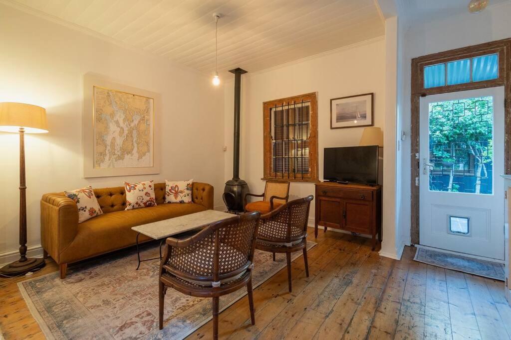 ein Wohnzimmer mit einem Sofa, einem Tisch und Stühlen in der Unterkunft Snug Haven Cottage in Kapstadt