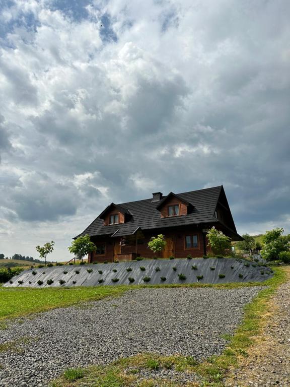 une maison avec un groupe d'oreillers devant elle dans l'établissement Cabanówka, à Hoczew