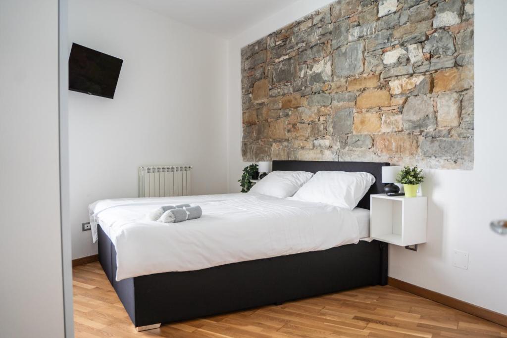 una camera da letto con un grande letto e un muro in pietra di 9b The Appartments a Trieste
