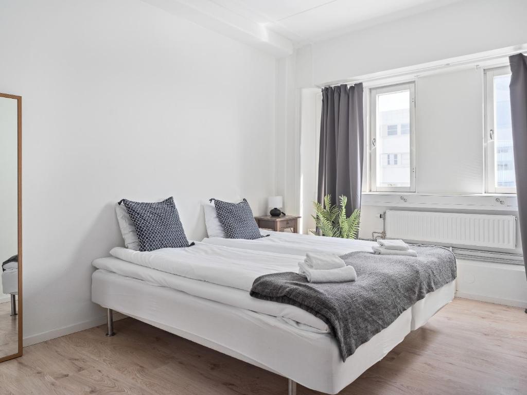 a white bedroom with a large white bed with a blanket at Part-Time Home Slagsta Strand in Norsborg