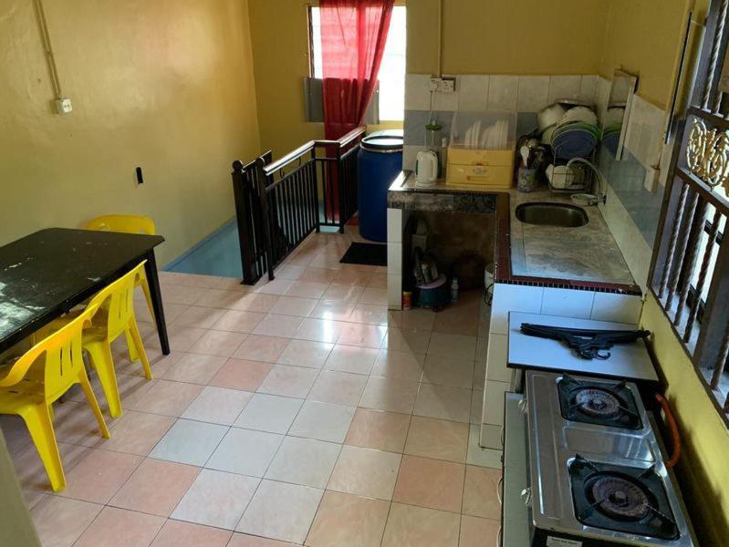 a kitchen with a stove and a counter top at Homestay Pokdin in Kuantan