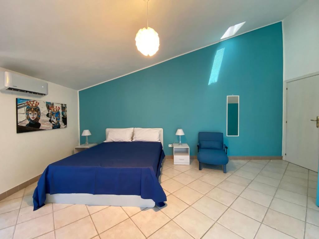 Dormitorio azul con cama y pared azul en La casetta della zia Nina, en Santo Stefano di Camastra