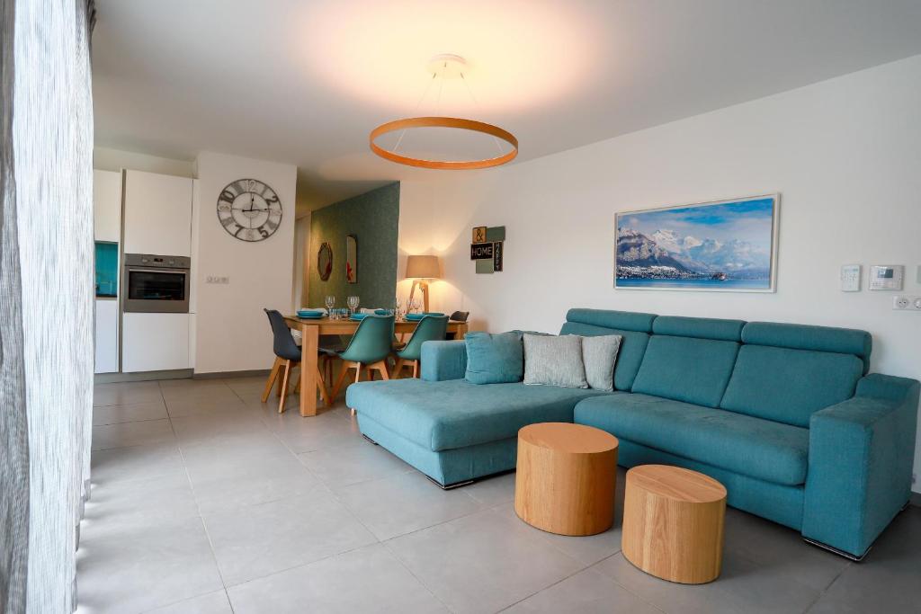 sala de estar con sofá azul y mesa en Le Bleu Du Lac 3 étoiles - Secteur recherché, Calme & familiale, à 300m du lac & de la vieille ville, Garage privé, en Annecy