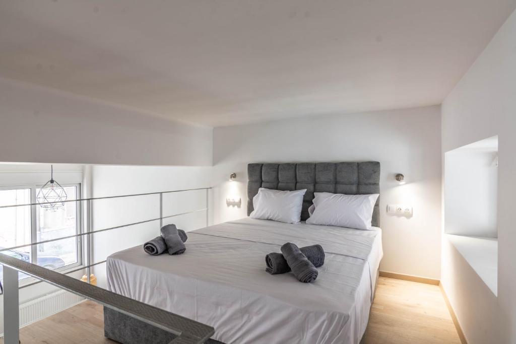 a white bedroom with a large bed with two pillows at Gazi Home in Athens