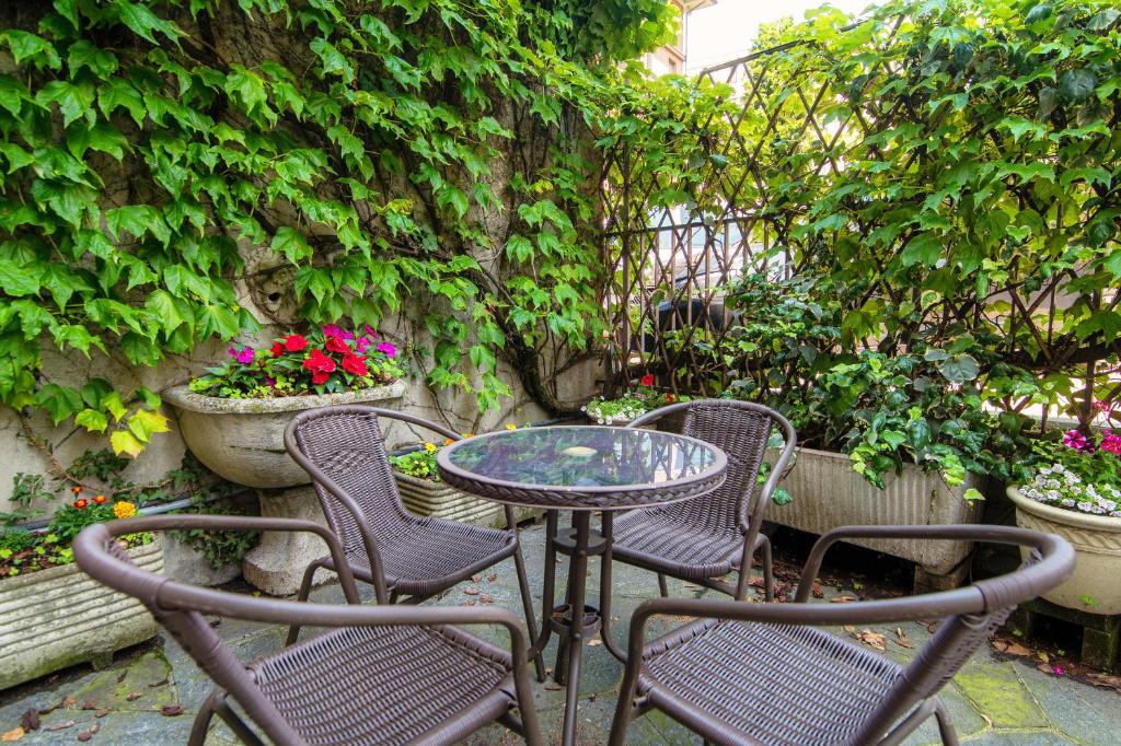 a patio table and chairs with flowers and plants at Mulino Nuovo by Quokka 360 - Spacious Apartment on the Swiss Border in Como