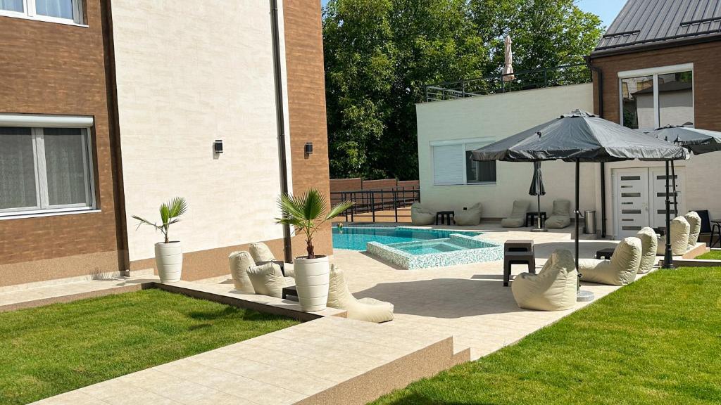 a patio with an umbrella and chairs and a pool at GOLDEN VIEW Sokobanja in Soko Banja
