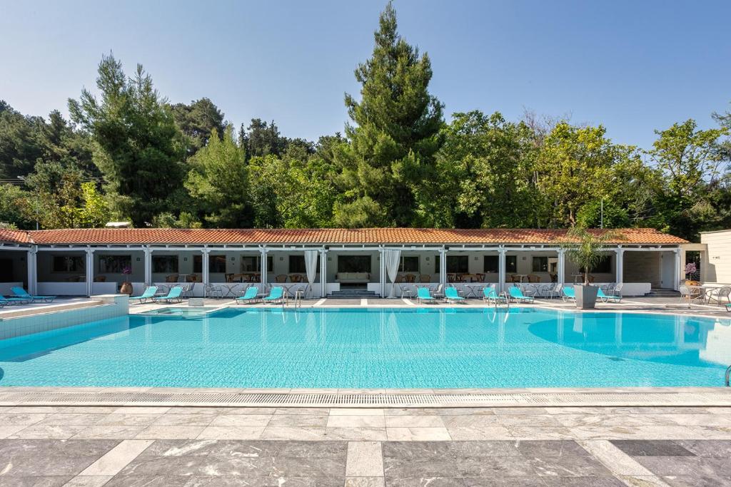 een groot zwembad met stoelen en een gebouw bij Sun Beach Hotel in Agia Triada