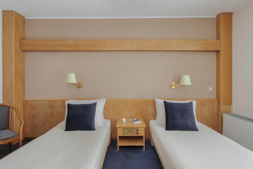 a room with two beds and a side table at Sun Beach Hotel in Agia Triada