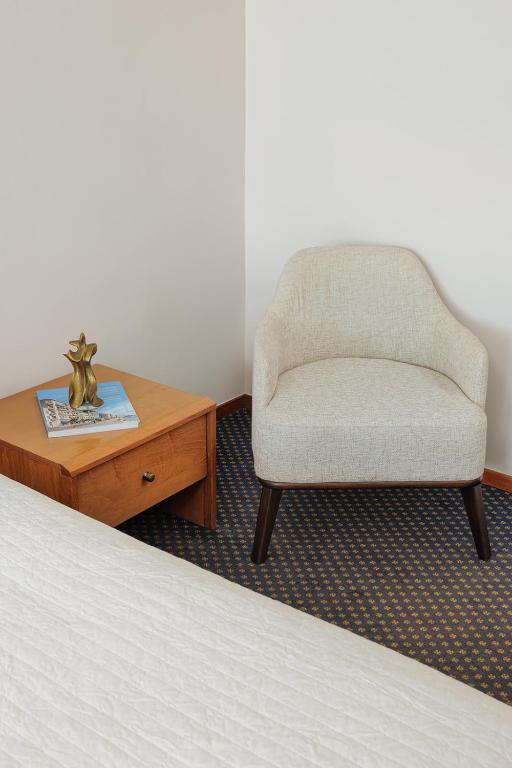 a bedroom with a bed and a chair and a table at Sun Beach Hotel in Agia Triada