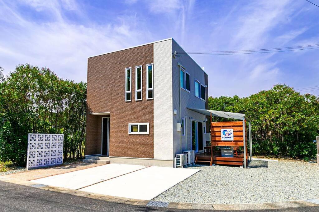 un petit bâtiment en briques sur le côté d'une rue dans l'établissement 白浜コンフォートファイブ, à Shirahama