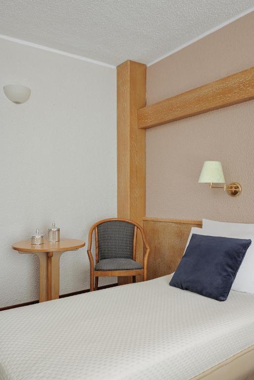 a bedroom with a bed and a chair and a table at Sun Beach Hotel in Agia Triada