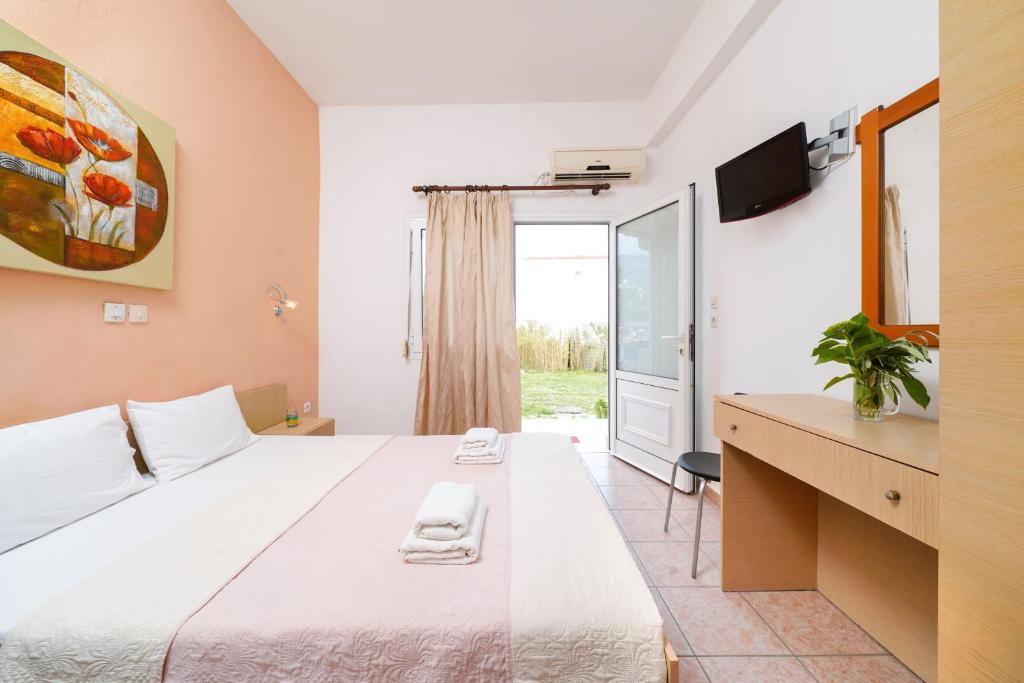 a hotel room with a large bed and a window at Studios Pinelopi in Skala Potamias
