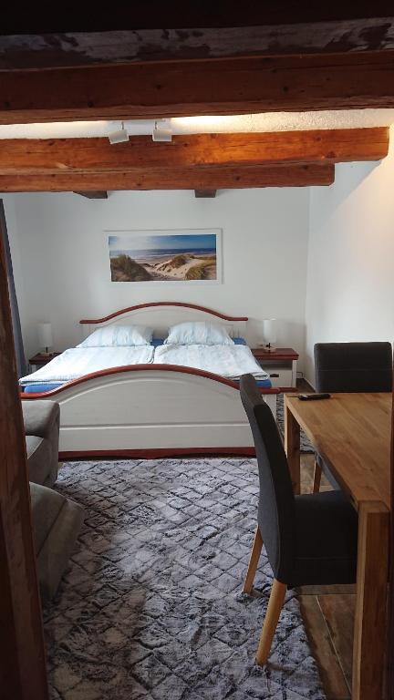 Schlafzimmer mit einem Bett, einem Schreibtisch und einem Stuhl in der Unterkunft Kleine gemütliche Ferienwohnung im Fachwerkstil in Wolfsburg