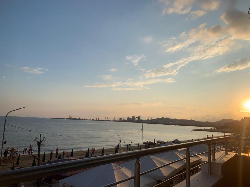 een groep mensen die bij zonsondergang op het strand lopen bij Appartamenti Nicola in Durrës