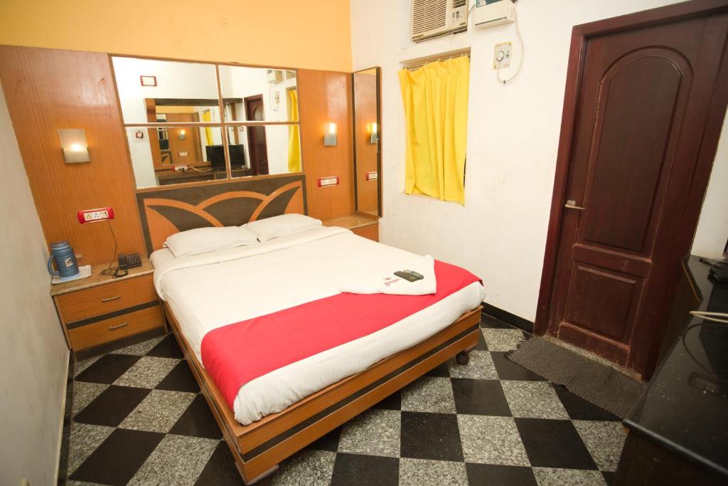 a bedroom with a bed and a checkered floor at Hotel Sunpark Inn in Chennai