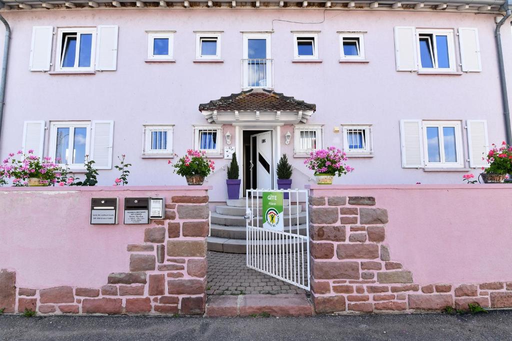 Casa rosa y blanca con puerta en Gite des Hirondelles, en Ostheim
