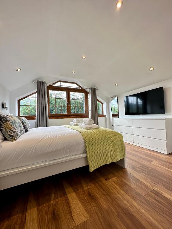 Un dormitorio con una cama grande y un televisor de pantalla plana. en 4 Sheraton Apartments, en Fort William