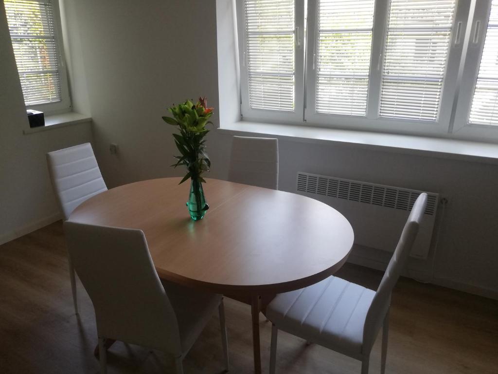 uma mesa de jantar com cadeiras e um vaso com flores em Maestro I. em Laško