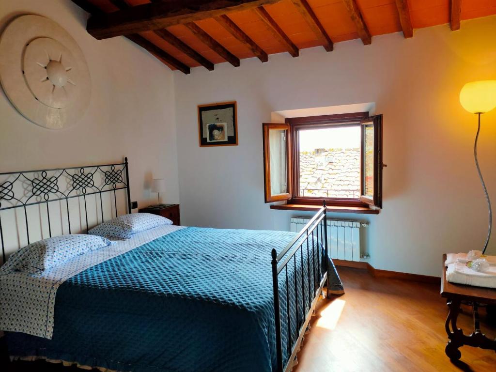 Un dormitorio con una cama azul y una ventana en casadipaola, en Gambassi Terme