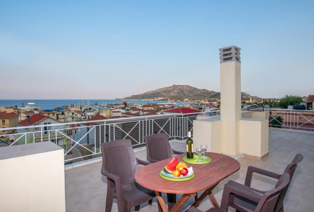 una mesa con una bandeja de fruta en el balcón en Coconut Tree House with port view en Zakynthos