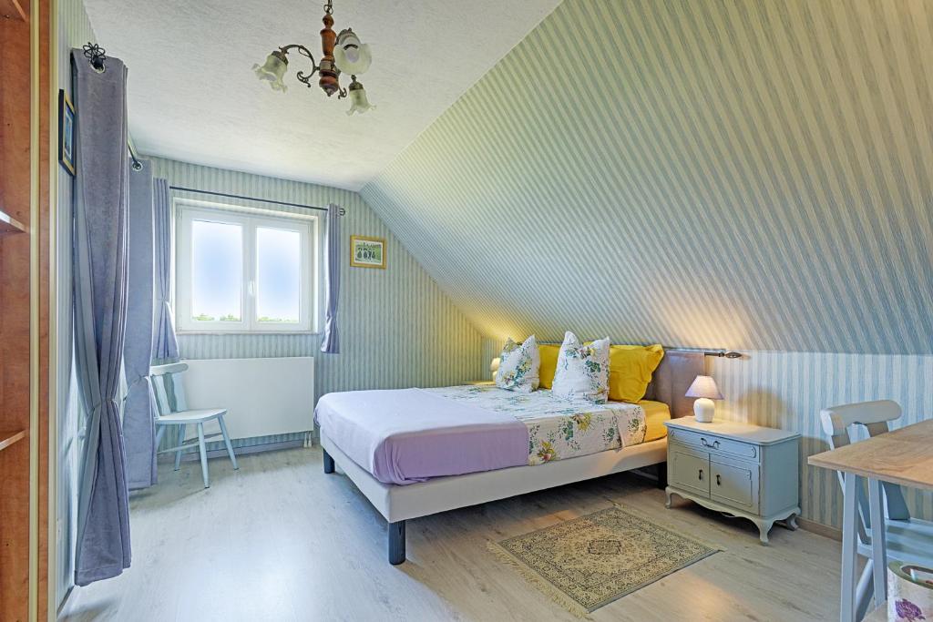 a small bedroom with a bed and a window at aux pieds des vignes in Ingersheim