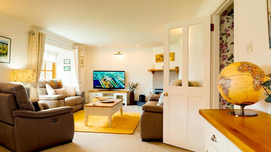 a living room with a couch and a table at Longfield, Daviot in Inverness