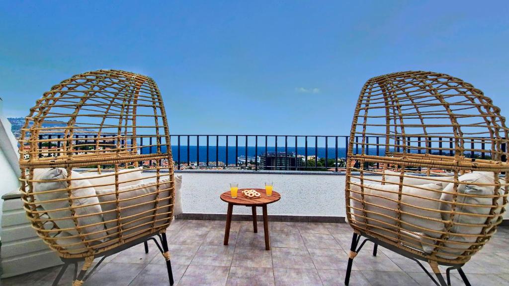 Duas cadeiras e uma mesa numa varanda em Costa Vista by LovelyStay no Funchal