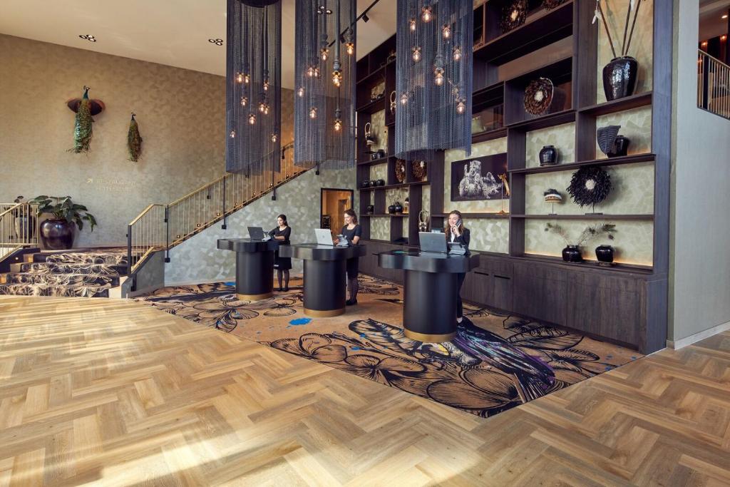 a room with two people sitting at tables in a store at Van der Valk Hotel Leusden - Amersfoort in Leusden